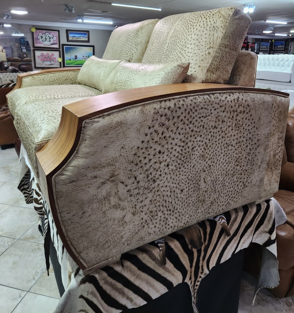 Side and walnut arm view of genuine ostrich leather sofa